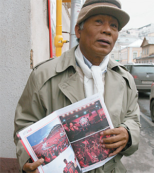 Тяран Дитхапхичай демонстрирует журнал тайских демократов—«красных» 