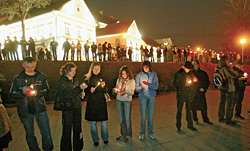 Случайные прохожие на улице Немига в Минске зажигают свечи в знак поддержки людей, раненных и арестованных в ходе разгона марша протеста 25 марта 2006 года