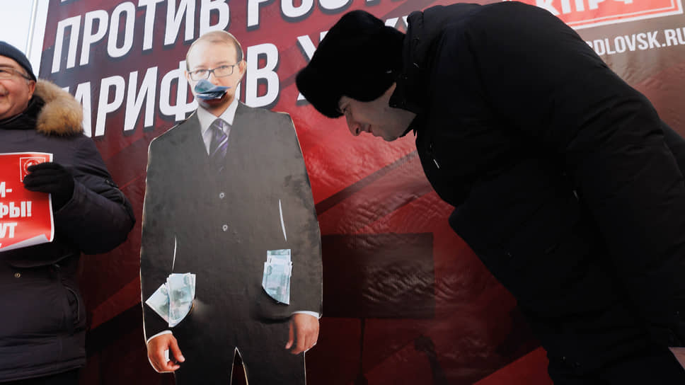 Участники митинга у картонной фигуры председателя РЭК Свердловской области Владимира Гришанова