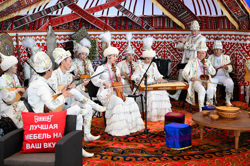 Музыканты в национальных костюмах во время выступления на стенде Казахстана