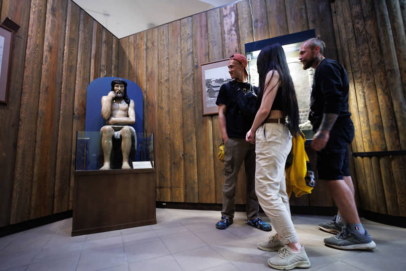 Посетители у деревянной скульптуры &quot;Страдающий Христос&quot; в Музее истории и археологии Урала