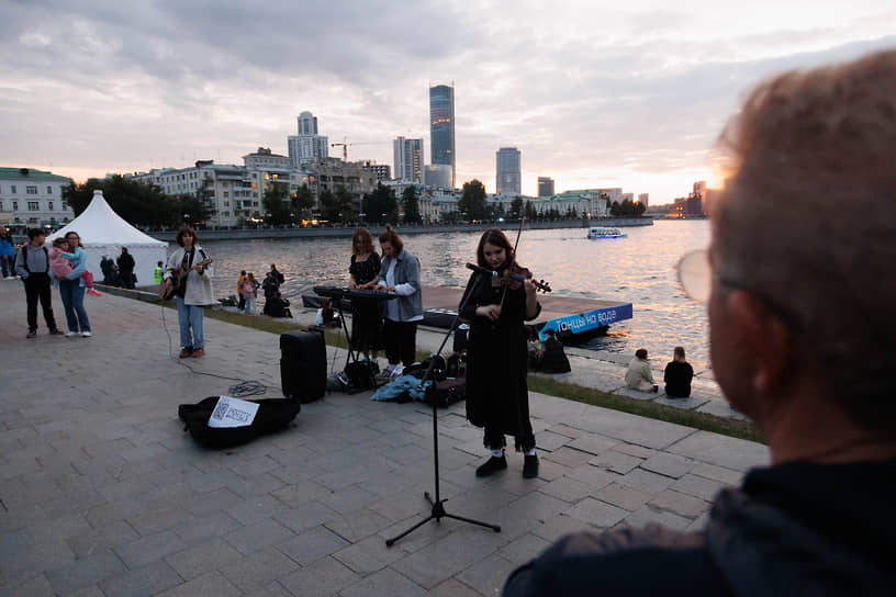 Выступление уличных музыкантов на набережной городского пруда