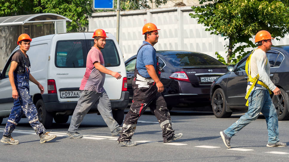 Рабочие гастарбайтеры переходят дорогу.