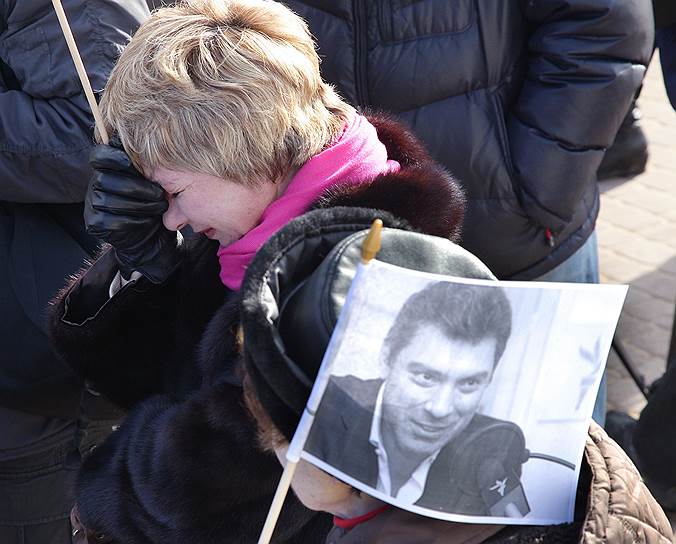 Март 2015 года. Женщина плачет на фоне флажка с портретом Бориса Немцова на траурном мероприятии в его память