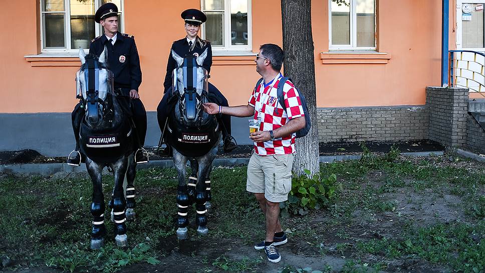 Иностранный футбольный болельщик общается с нарядом конной полиции. Июнь 2018 года