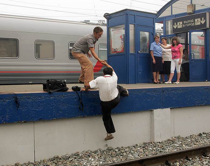 Репортеры перебегают железнодорожные пути в ожидании первого поезда &quot;Сапсан&quot;. Июль 2010