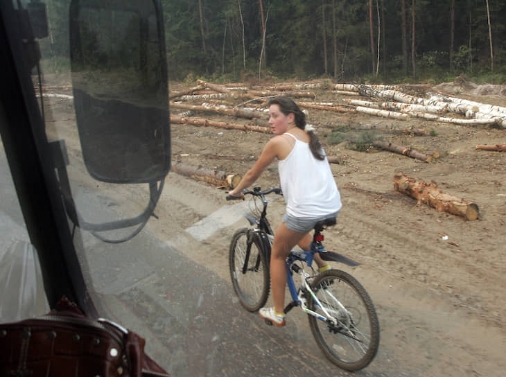 Жительница Выксунского района едет вдоль обочины дороги мимо сгоревшего и вырубленного леса