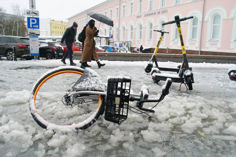 Упавший в сугроб после снегопада прокатный велосипед