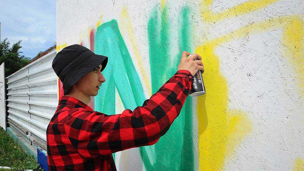 Молодой человек рисует гигантскую букву N на фестивале стрит-арта у кинотеатра «Маяковский»