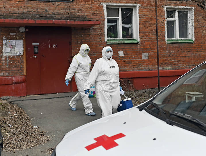 Сотрудники Скорой медицинской помощи в защитных костюмах у подъезда жилого дома в Омске. 28 апреля стало известно, что в регионе скончался второй пациент с COVID-19