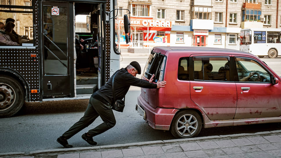 Мужчина толкает автомобиль в Новосибирске