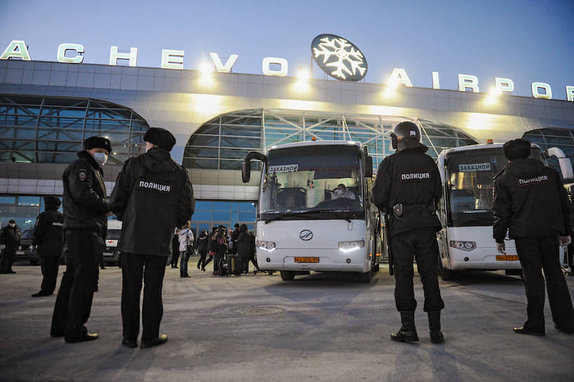 Сотрудники полиции контролируют посадку пассажиров в аэропорту Толмачево в автобусы для доставки их в обсерваторы 