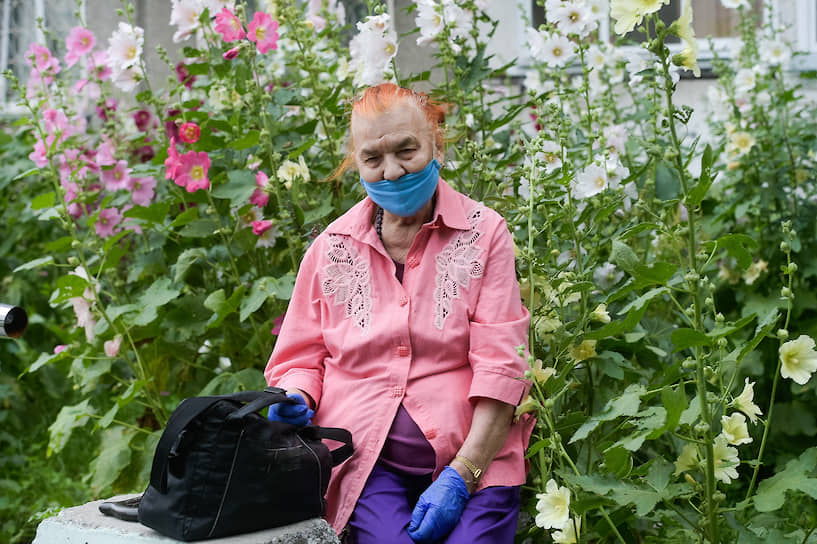 Женщина в маске и перчатках отдыхает на улице в Новосибирске после смягчения карантинных мер из-за коронавируса COVID-19