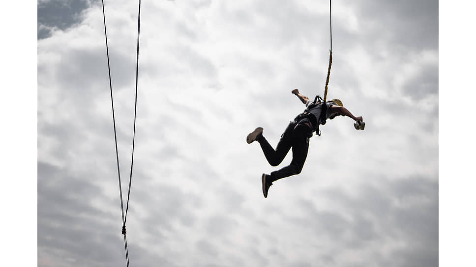 Прыжки с высоты на альпинистской веревке (роупджампинг) в клубе «ZigZag» с Бирюлевского моста, Кемеровская область. Мужчина во время прыжка
