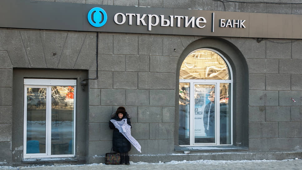 Пожилая женщина продает вещи возле входа в банк «Открытие» в Новосибирске
