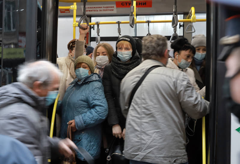 Новосибирск в период ограничительных мер во время второй волны коронавирусной инфекции. Пассажиры в медицинских масках толпятся в салоне автобуса