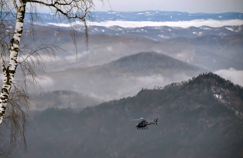 Вертолет в небе над горнолыжным курортом Манжерок в Республике Алтай