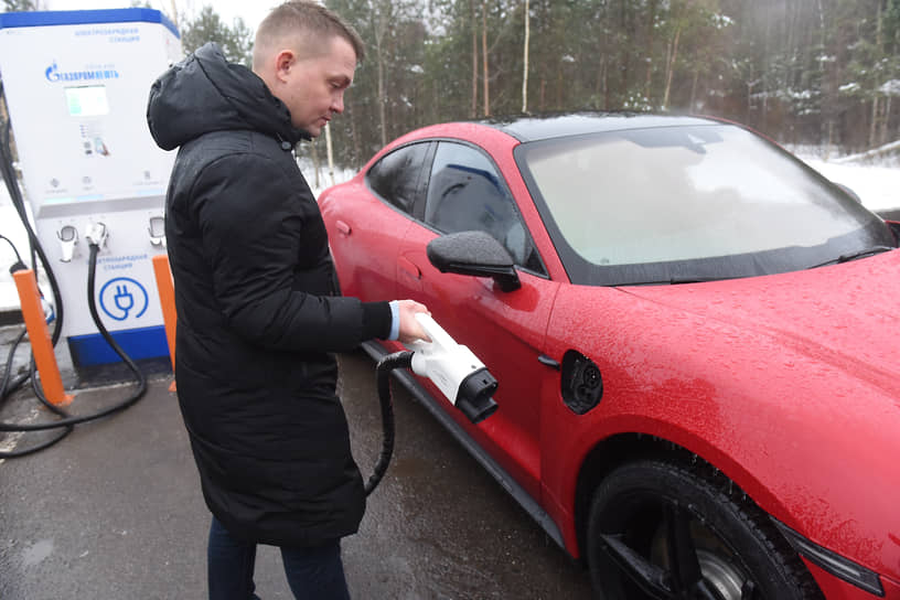 Владелец электрокара Porsche во время зарядки автомобиля на станции "Газпромнефть" 