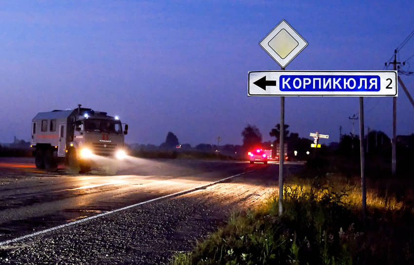 Последствия крушения вертолета Росгвардии возле населенного пункта Корпикюля в Гатчинском районе Ленинградской области. Машина Росгвардии выезжает на трассу на фоне дорожного указателя &quot;Корпикюля&quot;