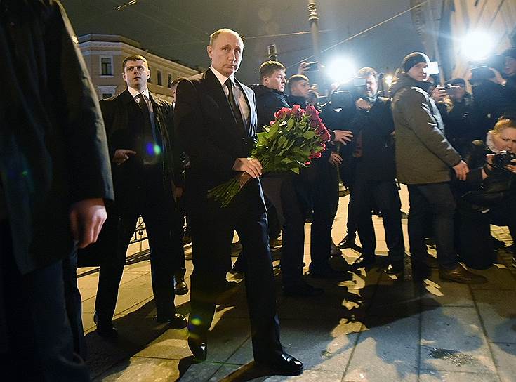 Президент России Владимир Путин (в центре) во время возложения цветов к месту трагедии