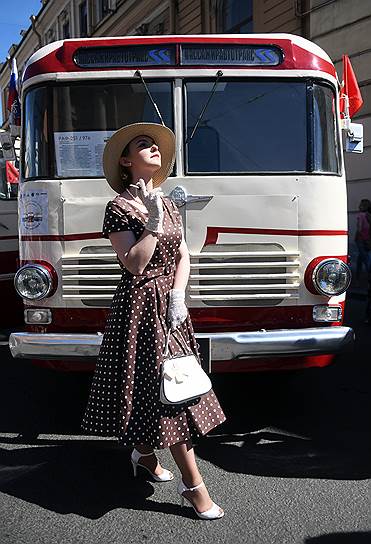 Девушка в стиле 50-х годов позирует на фоне старого автобуса во время празднования 315 годовщины образования Санкт-Петербурга