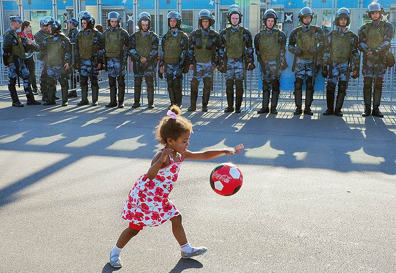 Сотрудники полиции перед началом футбольного матча на стадиона &quot;Санкт-Петербург&quot; и девочка играющая с мячом