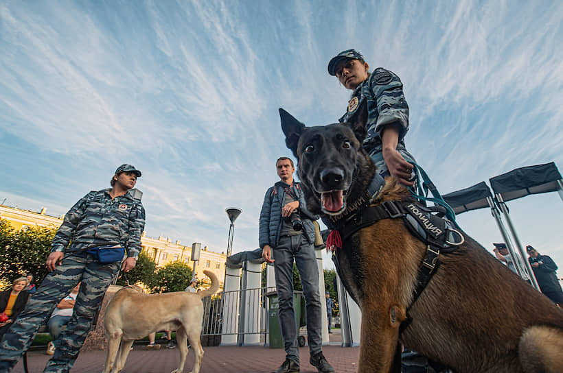 Сотрудник полиции со служебной собакой перед митингом &quot;Против произвола на выборах&quot; на Площади Ленина
