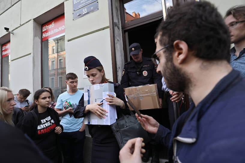 Сотрудники полиции выносят документы из петербургского штаба оппозиционера Алексея Навального после обыска