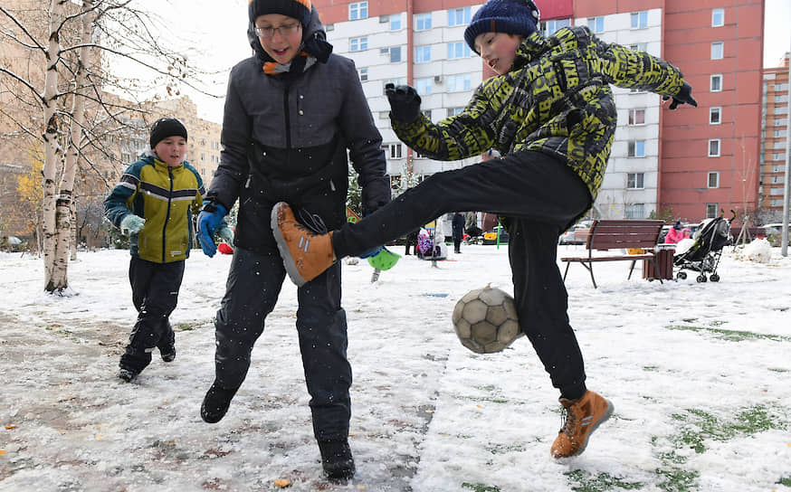 Первый снег. Дети играют в футбол во дворе