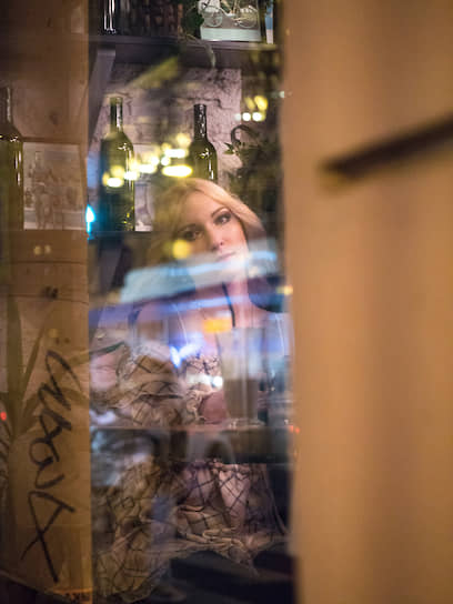 Девушка в кафе за витринным стеклом