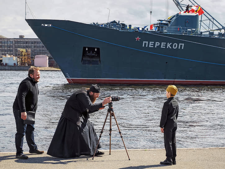 Празднование 75-ой годовщины Победы в Великой Отечественной войне. Священник фотографирует мальчика на фоне учебного корабля &quot;Перекоп&quot;