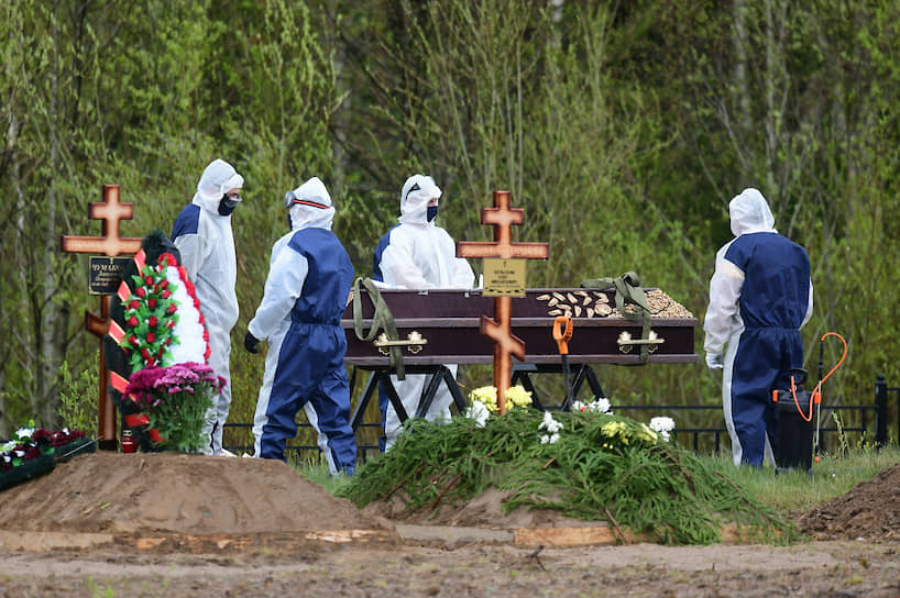  Сотрудники кладбища "Илики" во время похорон женщины, погибшей от COVID-19