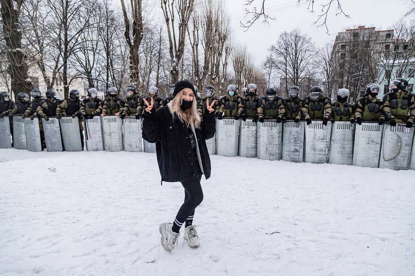 Несогласованная акция сторонников оппозиционера Алексея Навального в центре города. Девушка позирует на фоне оцепления сотрудников силовых органов