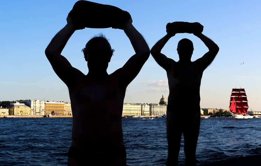 Мужчины делают разминку с камнями на пляже у Петропавловской крепости на фоне брига &quot;Россия&quot; во время репетиции праздника выпускников &quot;Алые паруса&quot;
