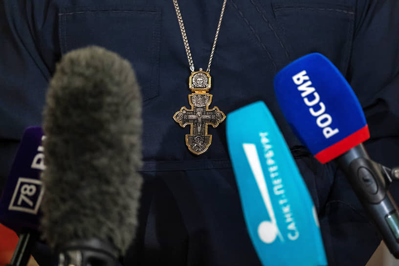 Православный крест священника и микрофоны телеканалов Санкт-Петербурга