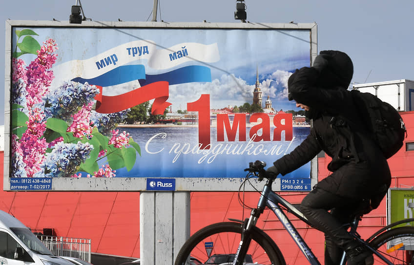 Велосипедист на фоне первомайского баннера &quot;Мир, труд, май&quot;