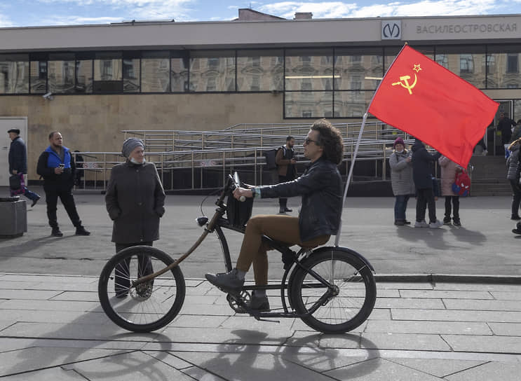 Мужчина на велосипеде с флагом СССР у метро Васильеостровская