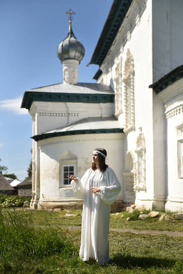 Художница Соня Кислякова в своем выставочном платье в Каргополе на фоне церкви Рождества Богородицы