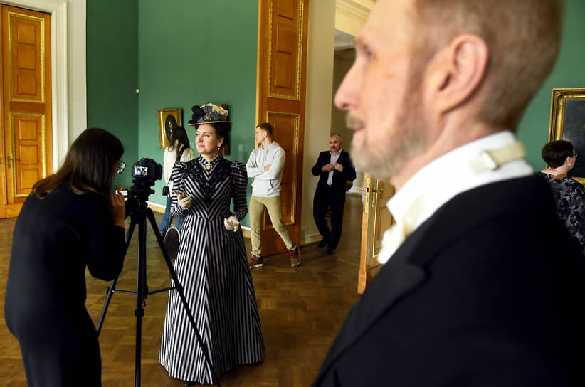 Посетители актеры в ролях исторических личностей конца XIX столетия в одном из залов музея