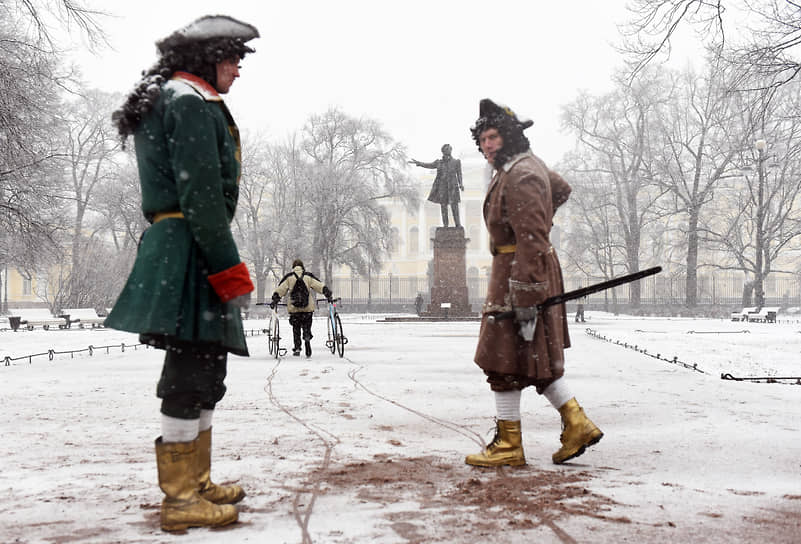 Актеры в исторических костюмах на площади Искусств во время снегопада