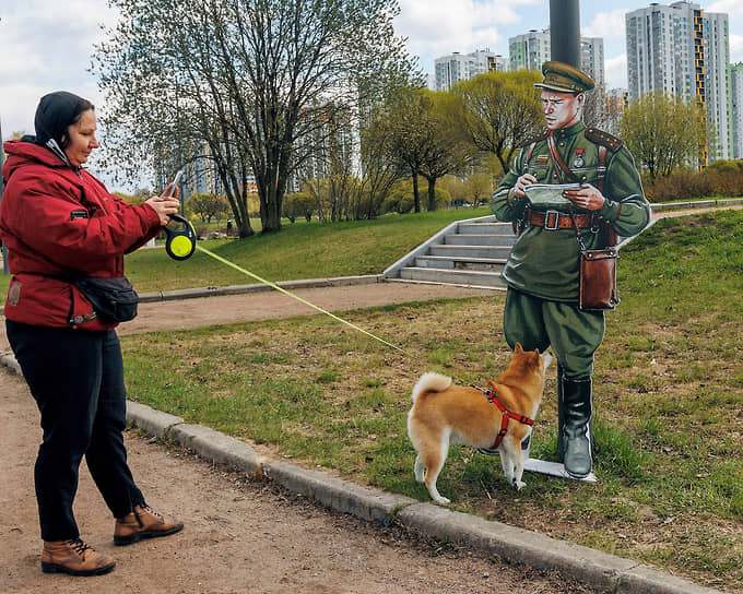 Хозяйка выгуливает свою собаку в парке на юге города