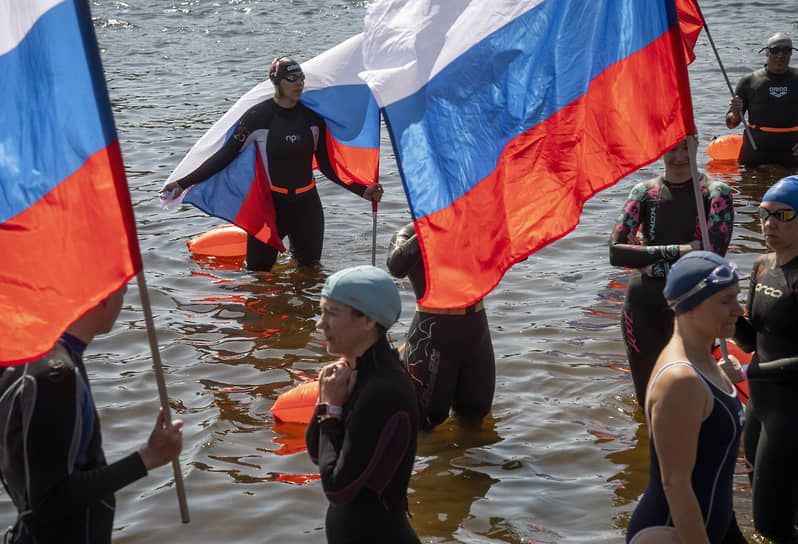 Празднование «Дня России». Люди в реке с Государственными Флагами России