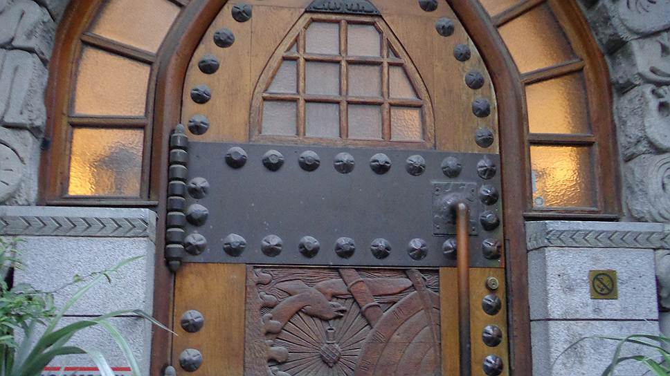 Дверь из массивного дерева декорирована вставками из стекла и металлом художественной обработки