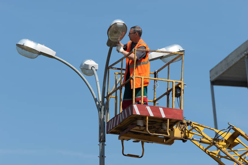 Монтаж светильников на опорах. Монтаж опор уличного освещения. Магнитогорские электрические сети здание. Светильник на опоре лэп. Монтаж светильников наружного освещения.