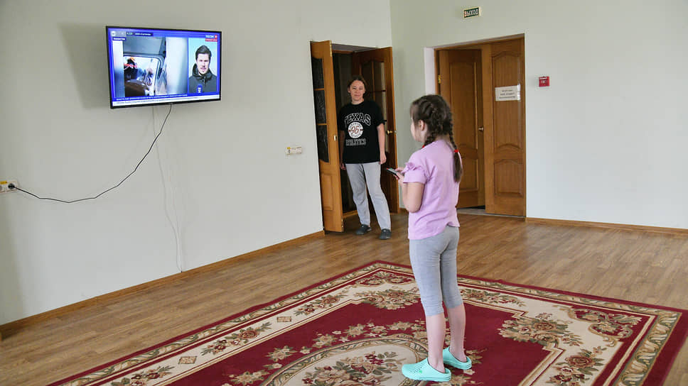 Дочь Анны Поповой смотрит телевизор в фойе