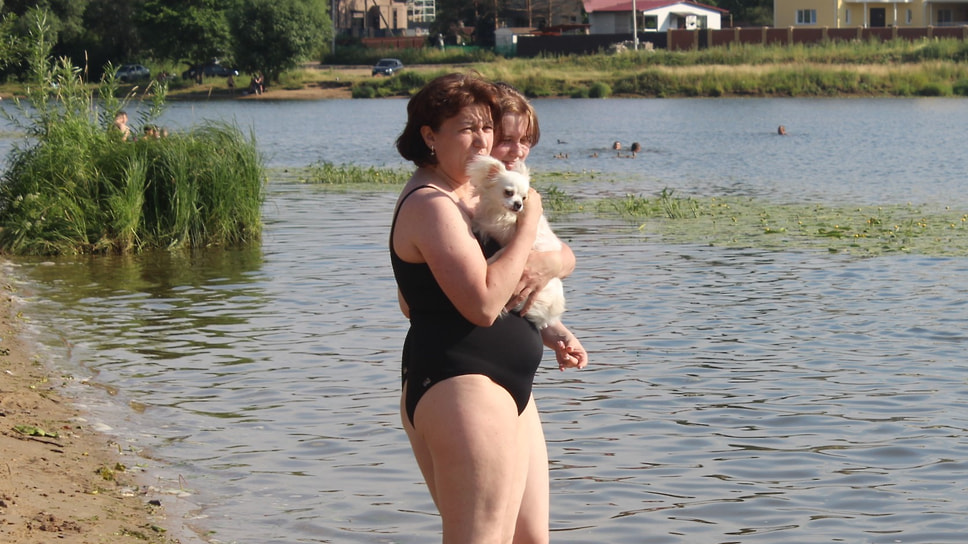 В такую жару в воду просятся даже домашние питомцы. На фото хозяйка собачки заходит в воду вместе со своей любимицей