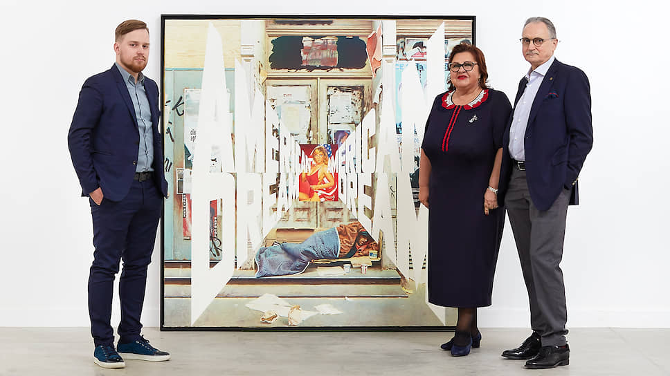 Михаил Овчаренко, Дина и Янис Зузанс (справа) на фоне картины Эрика Булатова «American Dream»  
