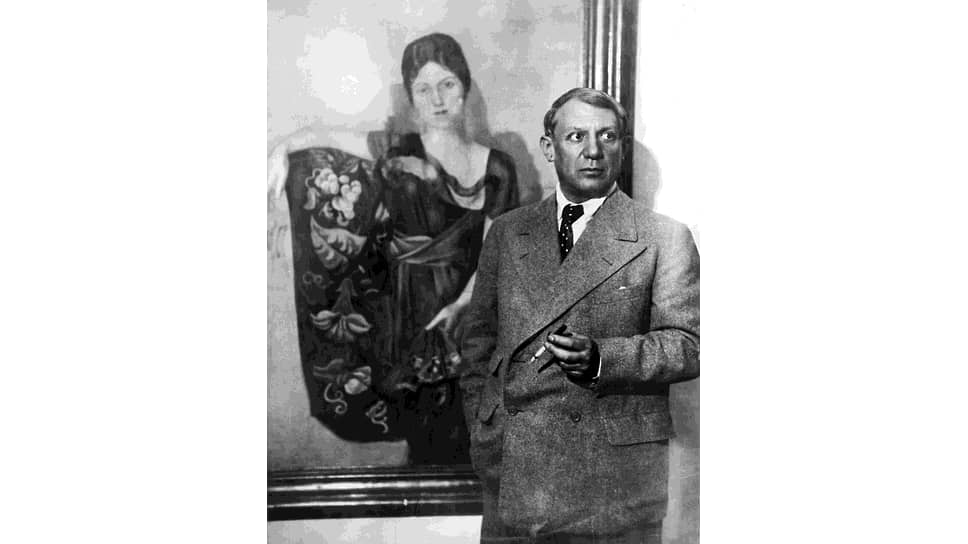 Пабло Пикассо в сером фланелевом костюме возле портрета жены, приблизительно 1935 год