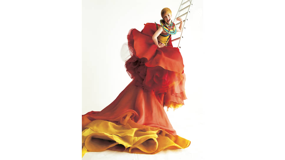 Модель Кайли Бакс в платье Kamata из коллекции сезона весна-лето 1997, первой кутюрной коллекции Джона Гальяно для Dior, где модельер использовал элементы платья Eloise самого господина Диора, показанного в 1948 году, и мотивы масаи для украшения зоны декольте и лифа