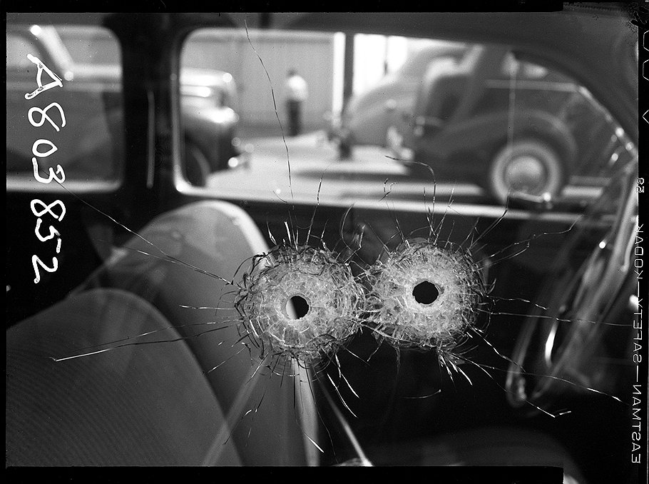 Крупный план пулевых отверстий в окне автомобиля Атти. Убийство. 1942 год